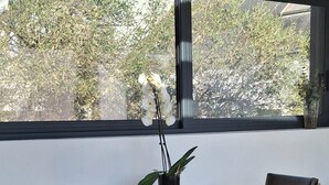 En matplats med ett bord, stolar och utsikt genom ett stort fönster.