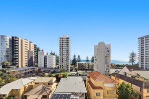 Une zone urbaine côtière caractérisée par des immeubles de grande hauteur, un mélange de bâtiments résidentiels et commerciaux, et une vue dégagée sur la mer.