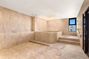 Une salle de bain moderne avec des carreaux hexagonaux, une baignoire et une vue sur un immeuble par la fenêtre.
