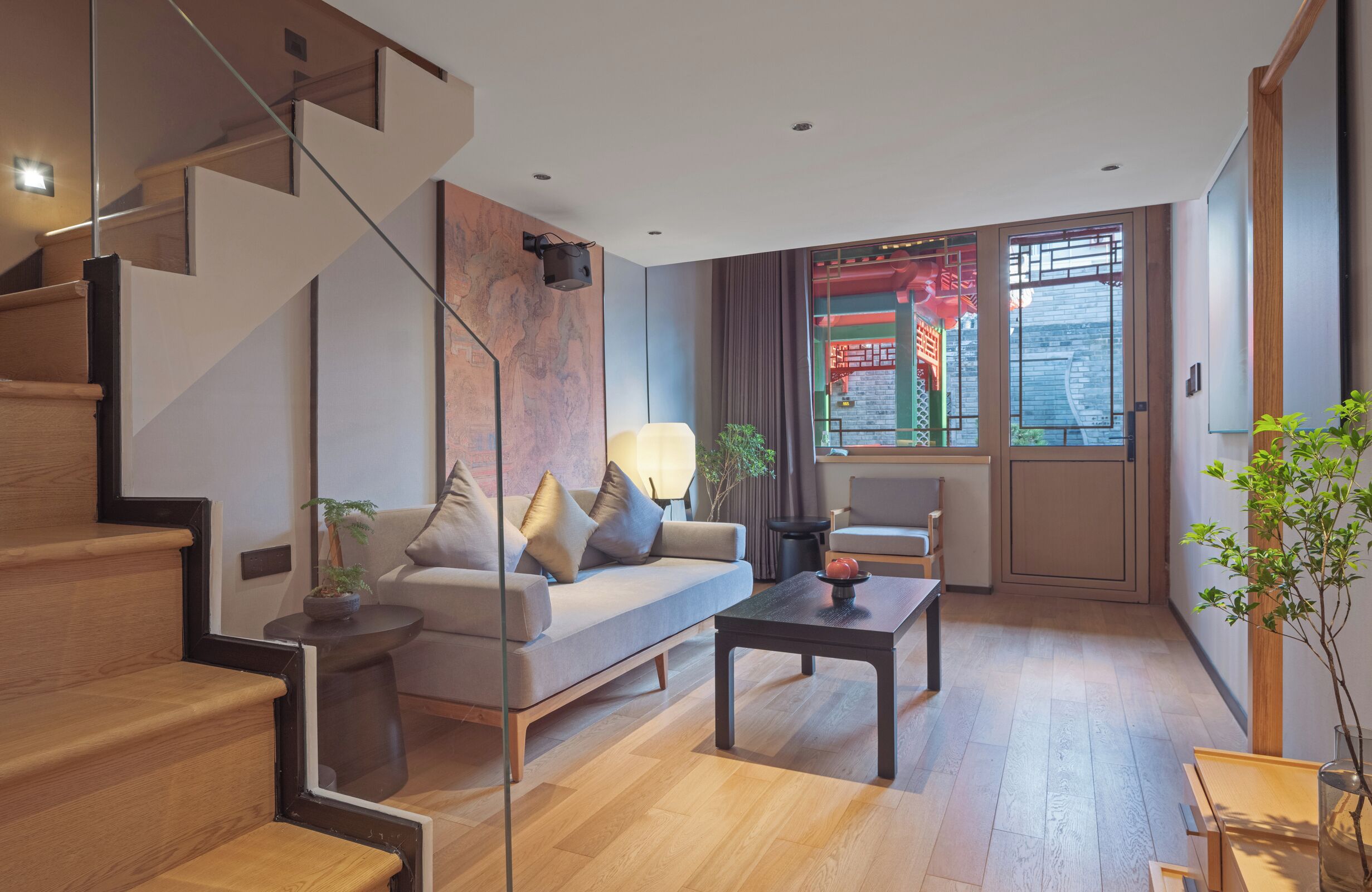 A modern living room with a sofa, coffee table, and staircase.