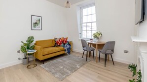 Una sala de estar moderna con sofá, sillones, una mesa de comedor y una chimenea.