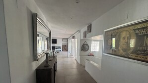 A hallway with a large framed artwork, a mirror, and a fireplace. - Ibiza Serenity Estate (Can fornet)