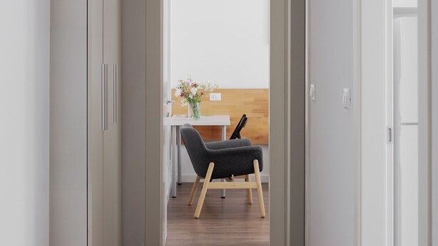 A narrow hallway with a wooden floor, leading to a room with a desk and a chair. - Strazzacappe Comfort Rooms by Wonderful Italy (Bologna)