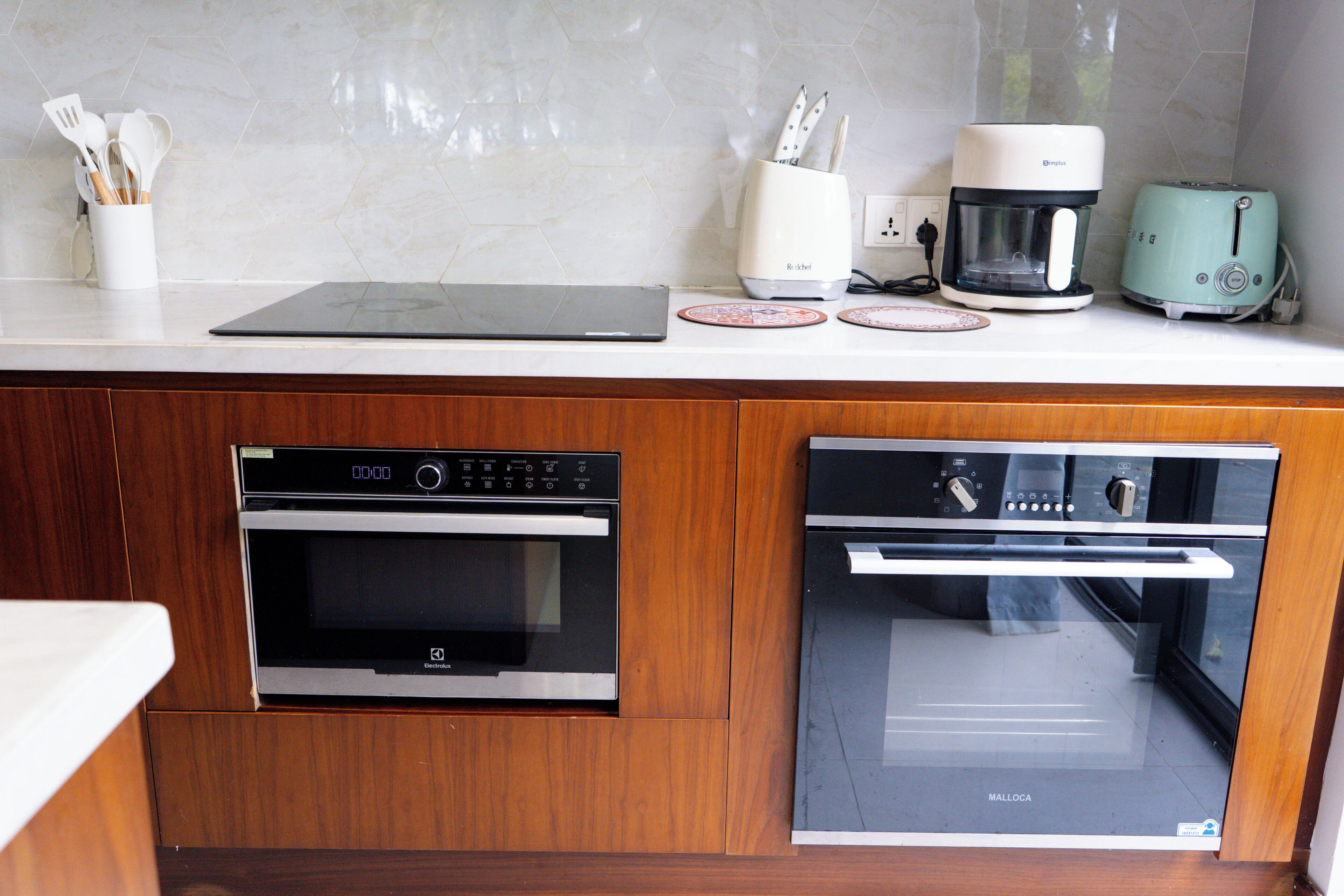 A kitchen with a built-in oven, a coffee maker, and a toaster on the countertop.