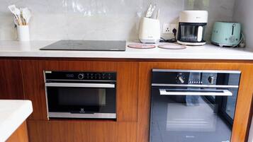 A kitchen with a built-in oven, a coffee maker, and a toaster on the countertop.