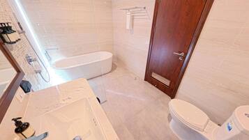 A bathroom with a bathtub, toilet, and sink.