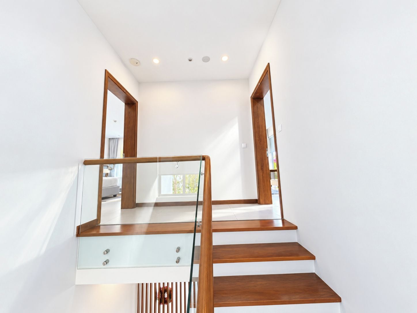 Un escalier moderne avec des rampes en verre et des marches en bois.