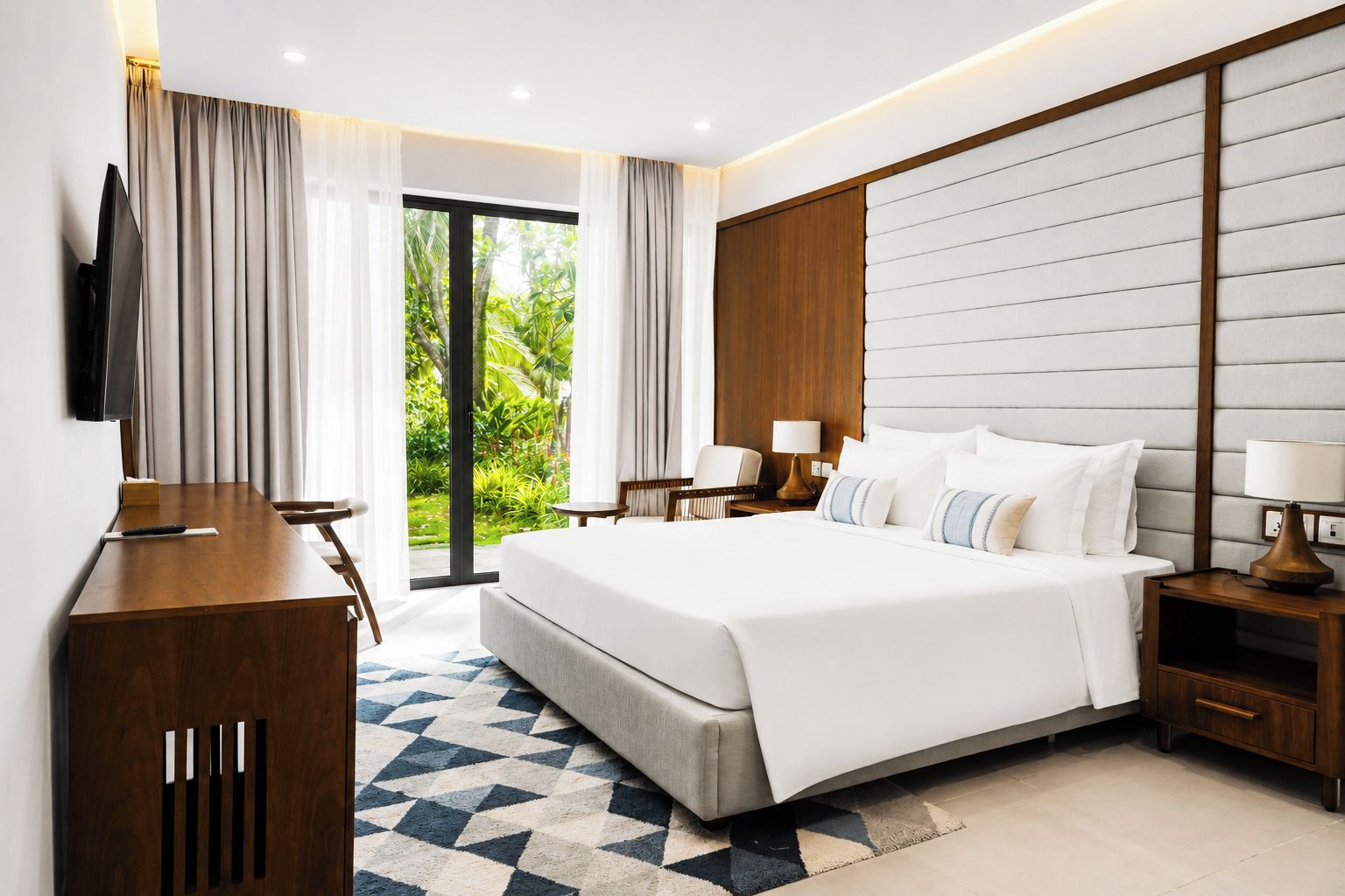 Habitación de hotel moderna con una cama grande, un escritorio, un televisor y vistas a zonas verdes.