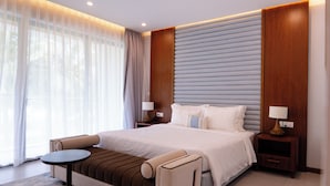 A modern hotel room with a large bed, a small round table, and a sofa.