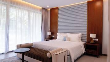 A modern hotel room with a large bed, a small round table, and a sofa.