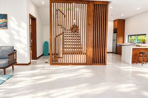 A modern interior with a staircase, a kitchen area, and a seating area. - Sonasea Villas Collection Long Beach Phu Quoc (Phu Quoc)
