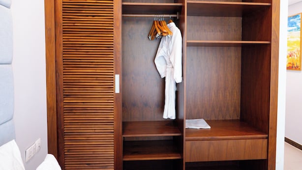 A wooden wardrobe with multiple shelves and hanging space.