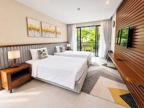 Ein Hotelzimmer mit zwei Betten, einem Fernseher, einem Balkon mit Blick auf Grünflächen und Kunstwerken an der Wand.