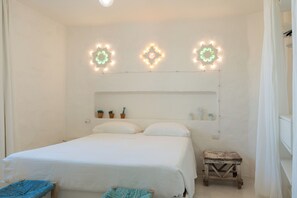 A bedroom with a bed, bedside tables, and decorative wall lights. - TRULLO EXCLUSIVE (Torre Vado)
