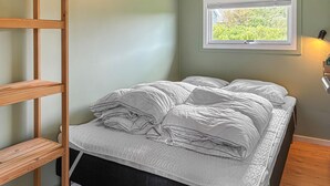 A bed with white bedding, a window with a view of greenery, and a wooden ladder. - Gorgeous home in Vestervig with WiFi (Vestervig)