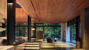 A modern interior with a wooden ceiling, a ceiling fan, and a seating area with a round table and chairs.