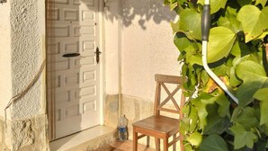 A door with a geometric pattern, a small window, a wooden chair, and a tiled floor.