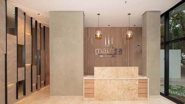 A reception desk with a wooden backdrop, two pendant lights, and a marble counter. - Corporate Stays Matrisa - 405 (Asunción)