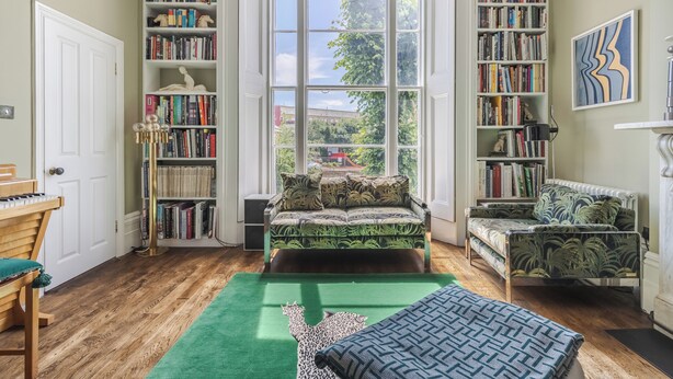 A room with a large window, a bookshelf, a sofa, a chair, and a piano. - The Mid-Century Modern Maisonette, by Veeve (London)