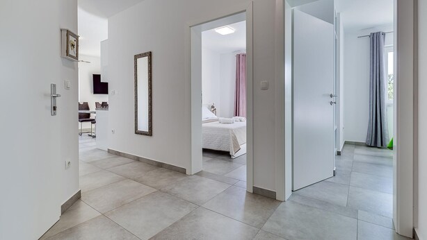 A modern hotel corridor with a bed, a bathroom, and a seating area. - Cozy apartment in Starigrad Paklenica with WiFi (Starigrad Paklenica)