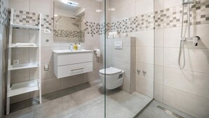 A modern bathroom with a glass shower enclosure, a white vanity with a mirror, and a toilet. - Cozy apartment in Starigrad Paklenica with WiFi (Starigrad Paklenica)