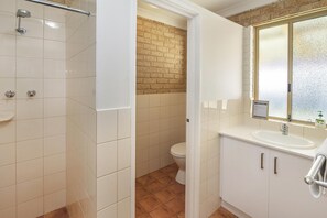 Ein Badezimmer mit Dusche, Toilette und Waschbecken.