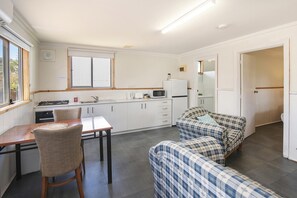 A compact kitchen with a dining table, chairs, and a kitchenette. - Riverscape Cottage No.4 - Riverscape Cottage No.4 is an easy walk to the Blackwood River (Augusta)
