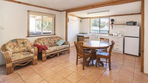 Una habitación acogedora con sofá, mesa de comedor y zona de cocina.