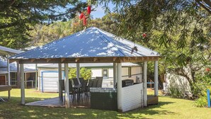 A covered outdoor seating area with tables and chairs, a barbecue grill, and a small garden. - Riverscape Cottage No.8 with River Views - Riverscape - unit 8 with views over the Blackwood River (Augusta)