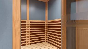 Un petit sauna d’angle avec des lambris en bois et un banc.