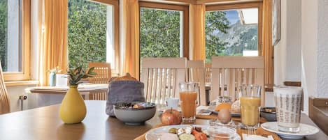 A breakfast table with a variety of food items, a glass of juice, and a cup of coffee.
