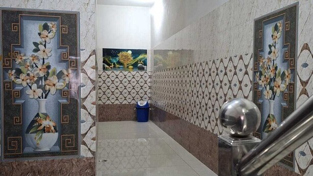 A hallway with a marble floor, patterned walls, and a metal handrail. - Sehrawat Guest House (Sakrai)