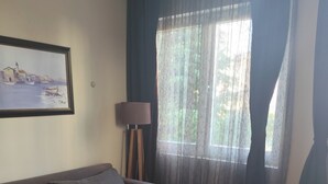 Ein Wohnzimmer mit einer Couch, einem Couchtisch, einer Lampe und einem Bild an der Wand.