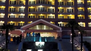 Ein mehrgeschossiges Hotel mit einem auffälligen 'Majestic'-Schild, mehreren Balkonen und einem zentralen Eingang mit einem Brunnen.
