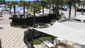 Ein Resort mit Poolbereich, Sitzgelegenheiten im Freien und Blick aufs Meer.