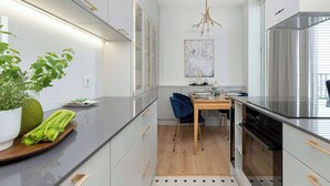 Eine moderne Küche mit einem Holzespeisetisch, einem Blumentopf und einer Pendelleuchte.