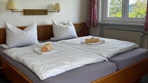 Ein Hotelzimmer mit Doppelbett, zwei Nachttischlampen, einem Fenster mit Blick und einer Heizung.