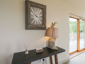 A framed clock, a lamp, and a small speaker on a table.