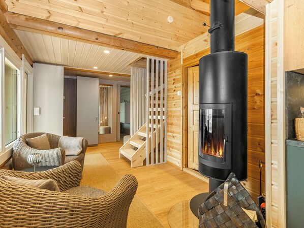 Una habitación acogedora con chimenea, muebles de mimbre y detalles de madera.