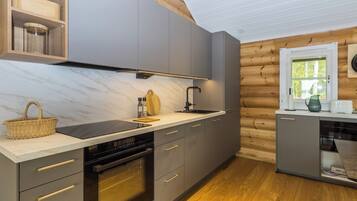 A modern kitchen with grey cabinets, a black stove, and a wooden floor.