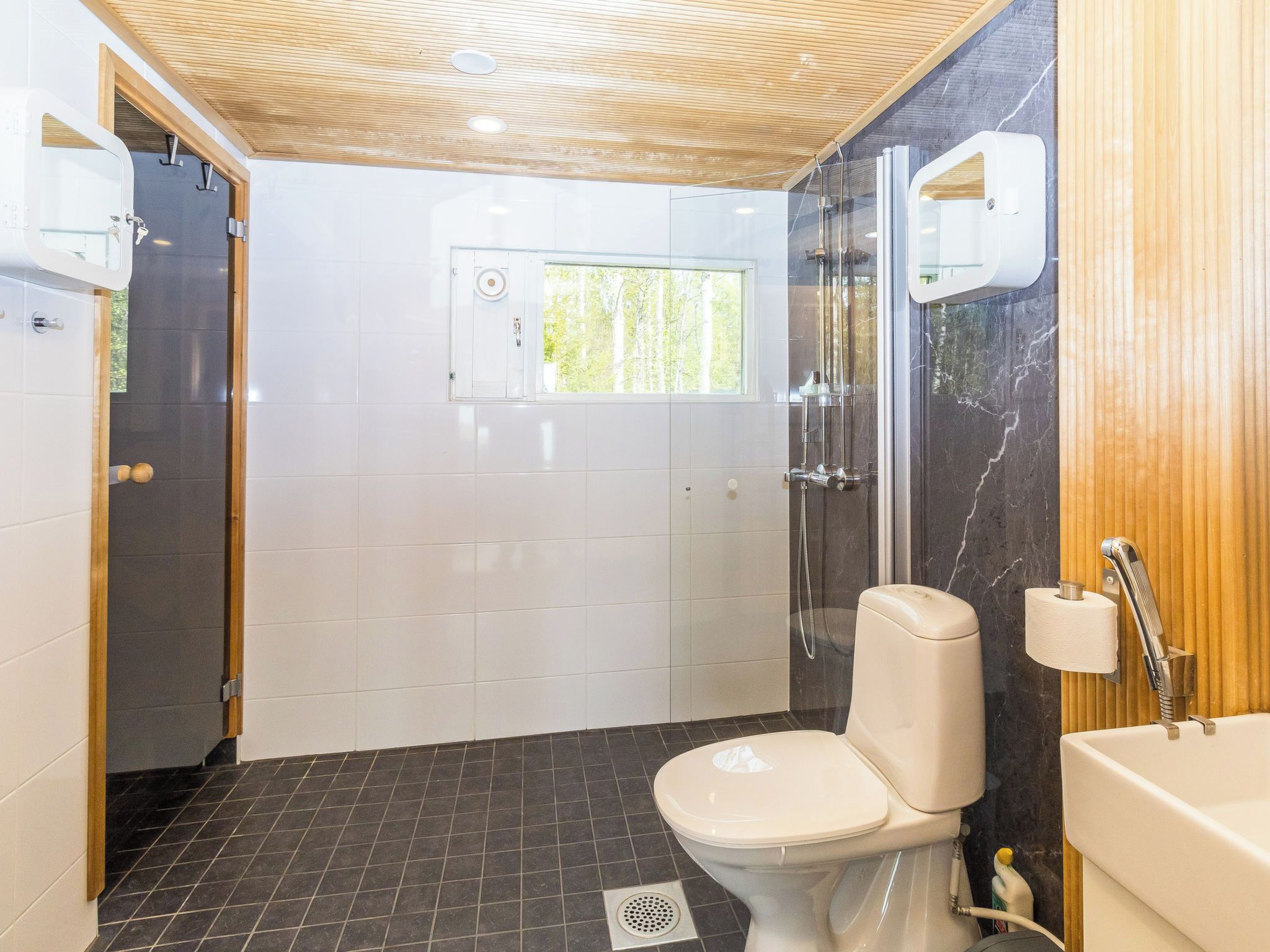 Moderni kylpyhuone, jossa on wc, suihku ja pesuallas.