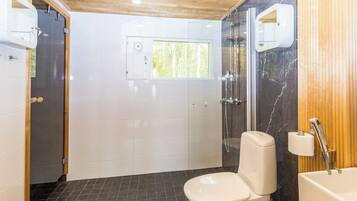 Moderni kylpyhuone, jossa on wc, suihku ja pesuallas.