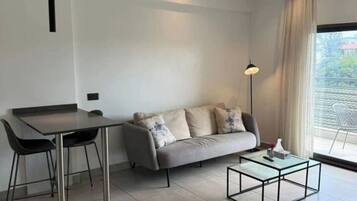 Deluxe Apartment, City View | Living area | 43-inch flat-screen TV with cable channels
