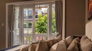 A room with a bed, a window with curtains, and a view of greenery outside. - Super lovely Villa in Phu My Hung by Ray (Ho Chi Minh City)
