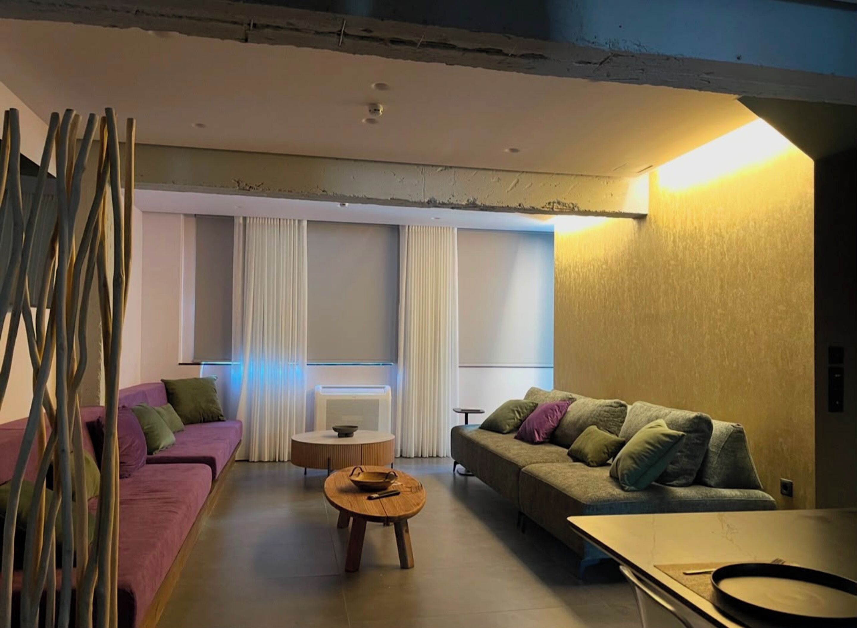 A modern living room with a sofa, a coffee table, and a dining table.