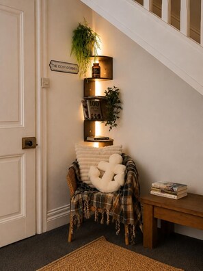 A staircase with a wall-mounted shelf holding books and a sign.