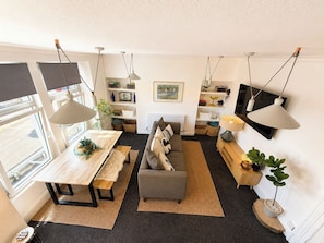 A modern living room with a sofa, a dining table, and a TV.