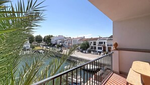 Ein Balkon mit Blick auf einen Yachthafen, einen Pool und Wohnhäuser.