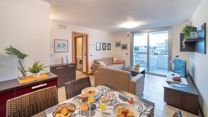 Um apartamento moderno com área de jantar, cozinha e varanda com vista para a cidade.