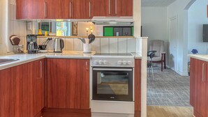 Una cucina moderna con mobili in legno, forno integrato e macchina da caffè.